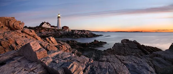Der Portland Head Lighthouse in Maine bei Sonnenuntergang auf felsiger Atlantikküste.
